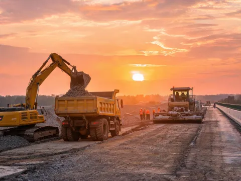 Excavator supporting highway base course prep